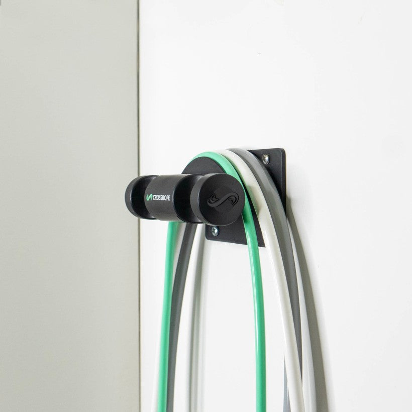 AMP Wall Mount Jump rope wall mount secured to the wall holding the 1/4, 1/2, and 1 LB jump ropes from Crossrope.