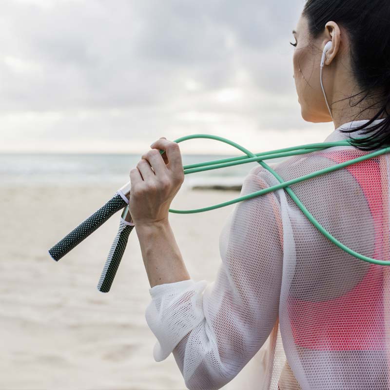 Slim + 1/4 LB Combo Woman holding Slim Handles with 1/4 LB Jump Rope