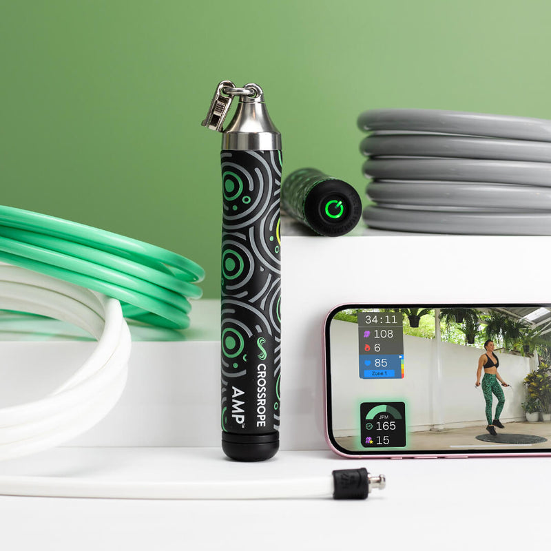 Product photo for AMP Jump Rope Set, including AMP Handles and 1/4 LB, 1/2 LB and 1 LB jump ropes with a smartphone showing a workout in progress