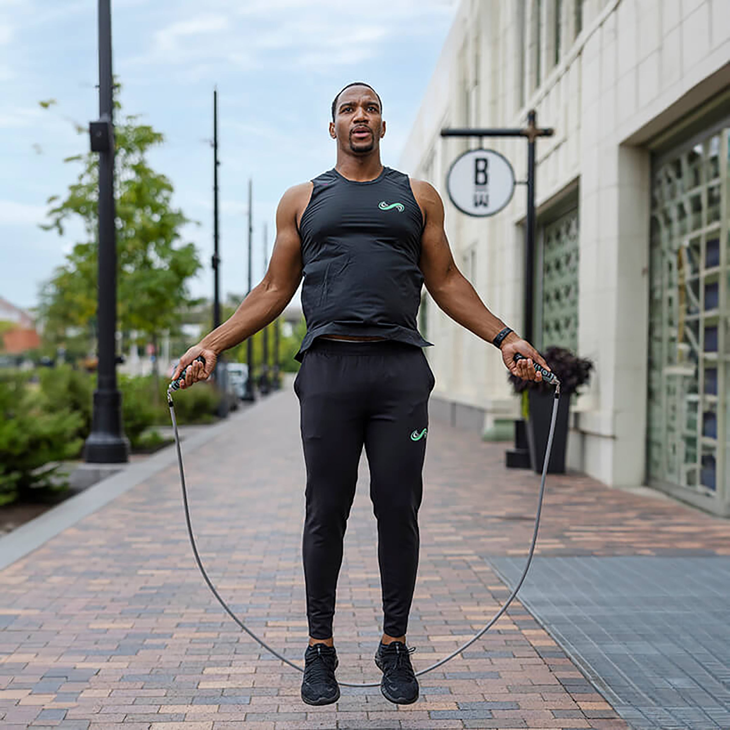 Get Strong Set Man jumping with a 1 LB jump rope on a city street