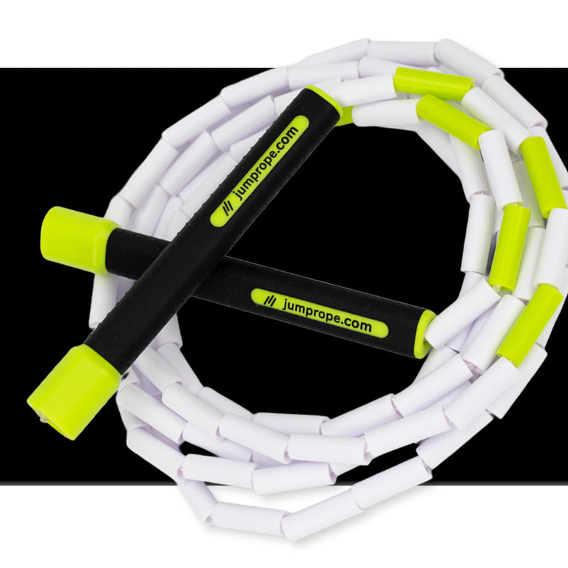 White jump rope with green handles on a black background