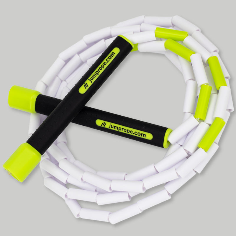 White jump rope with green handles on a light gray background