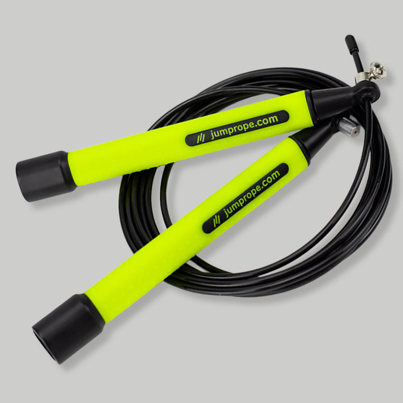 Jump rope with neon green handles and black cable on a light gray background