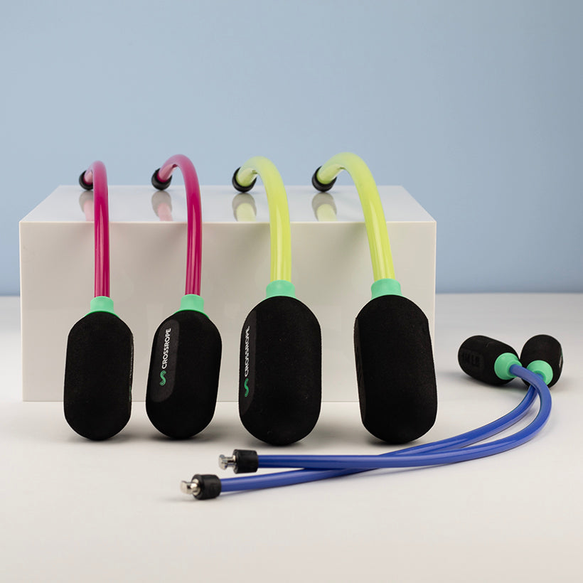 Ropeless AMP Vibe Set (LE) Set of Ropeless jump ropes with colorful cords on a white block against a light blue background